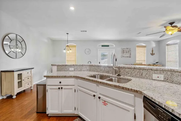 a kitchen with a sink cabinets and wooden floor