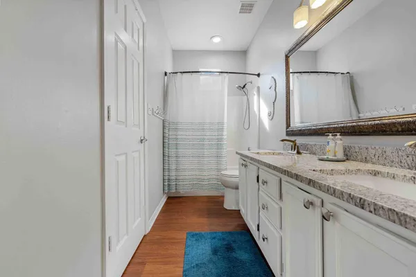 a bathroom with a granite countertop sink a large mirror and a shower