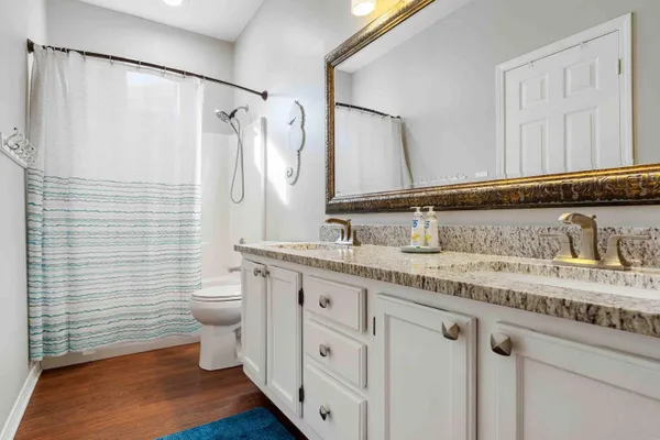 a bathroom with a granite countertop sink a toilet and a mirror