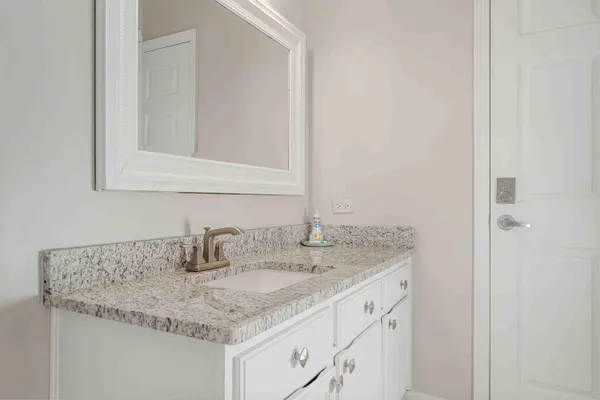 a bathroom with a granite countertop sink and a mirror