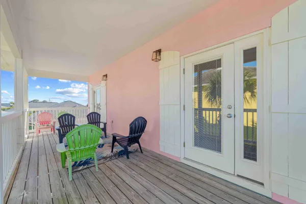 a view of a balcony with chairs and wooden floor