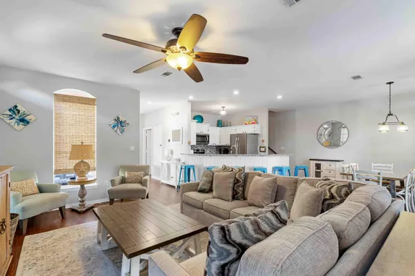 a living room with furniture kitchen area and a window
