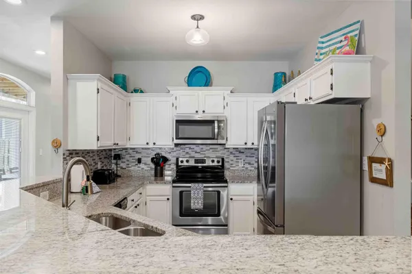 a kitchen with stainless steel appliances granite countertop a refrigerator and a stove top oven