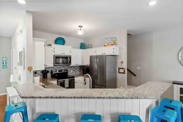 a kitchen with granite countertop a refrigerator and a sink