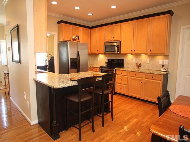 1806 Patterson Grove Road Apex, NC 27502 - Photo 8 of 25 Remodeled kitchen with stainless steel appliances, granite and tile back splash. Plenty of cabinet space! Breakfast bar is great for a quick meal or socializing.