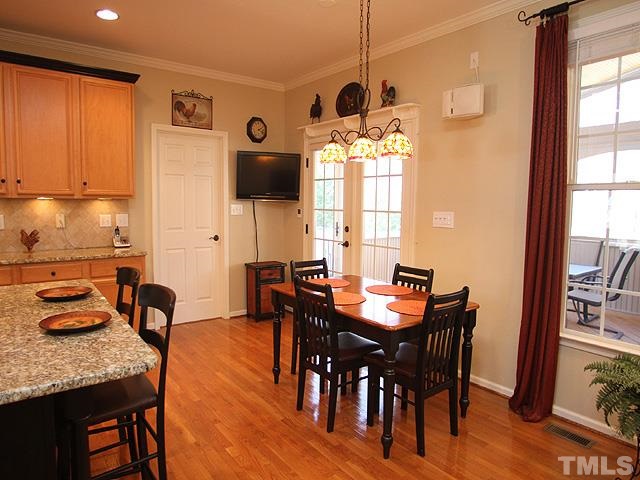 1806 Patterson Grove Road Apex, NC 27502 - Photo 9 of 25 Breakfast nook with Tiffany style lighting can accommodate a large table. Here you can see the double french doors that lead to the screen porch and back yard.