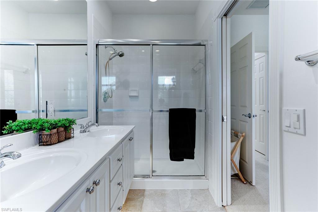 8334 Rimini Way Naples, FL 34114 - Photo 16 of 34 a bathroom with a double vanity sink and mirror