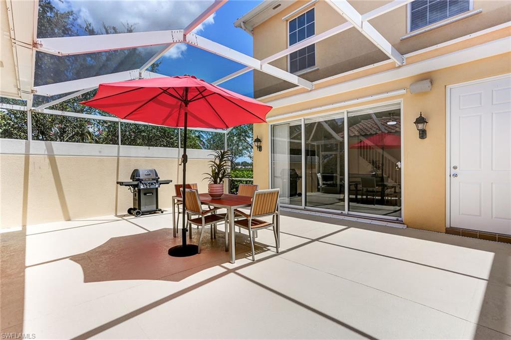 8334 Rimini Way Naples, FL 34114 - Photo 21 of 34 a view of a patio with a table and chairs under an umbrella