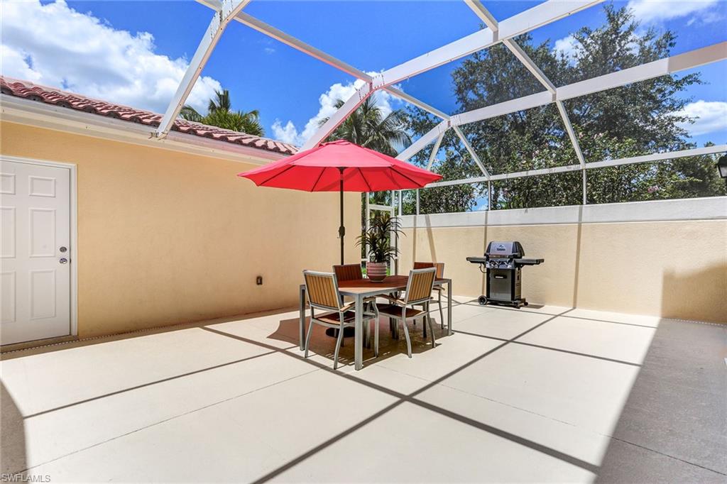 8334 Rimini Way Naples, FL 34114 - Photo 22 of 34 a patio with a table and chairs under an umbrella