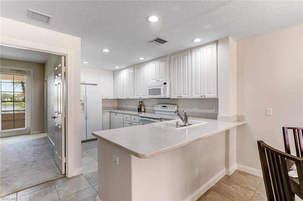 8334 Rimini Way Naples, FL 34114 - Photo 8 of 34 a kitchen with a sink white cabinets and stainless steel appliances