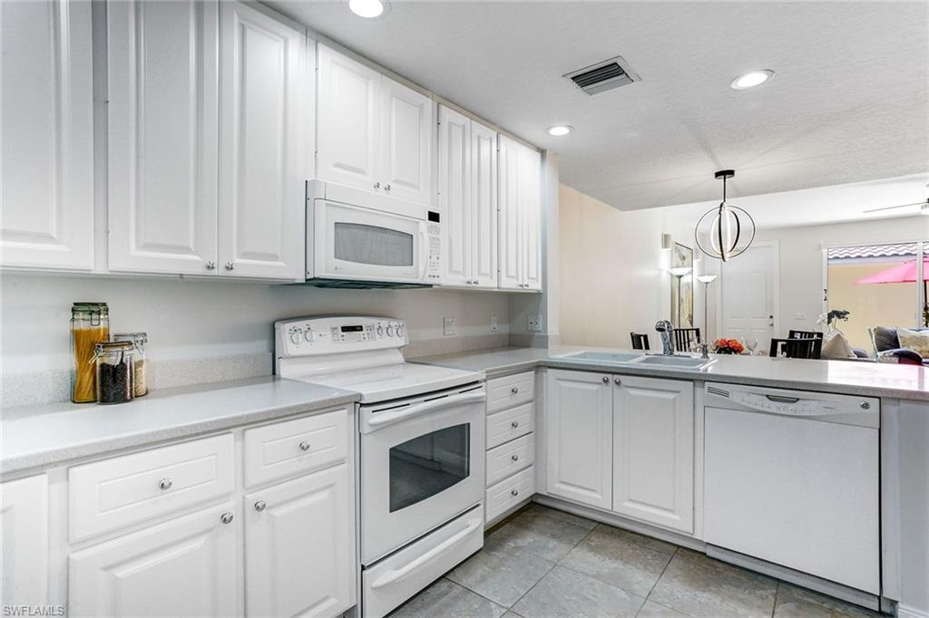 8334 Rimini Way Naples, FL 34114 - Photo 10 of 34 a kitchen with cabinets appliances a sink and a counter top space