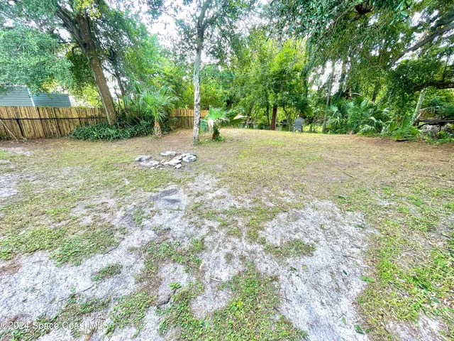 a view of a backyard with a garden and trees