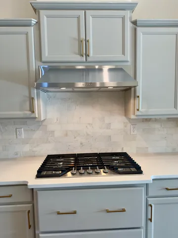 a stove top oven sitting inside of a kitchen