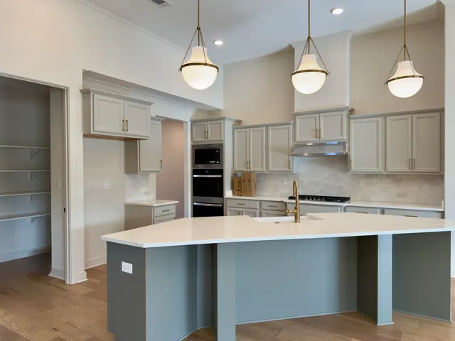a kitchen with kitchen island a sink stainless steel appliances and cabinets