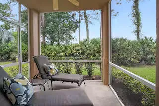 a balcony with wooden floor table and chairs