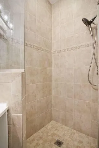 a bathroom with a sink vanity granite shower and a mirror