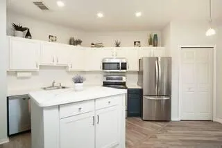 a kitchen with refrigerator cabinets and wooden floor