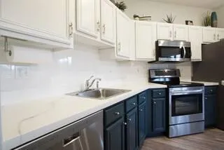 a kitchen with stainless steel appliances a sink a stove and a microwave