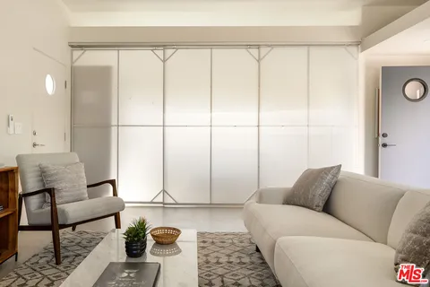 a living room with furniture and a view of kitchen