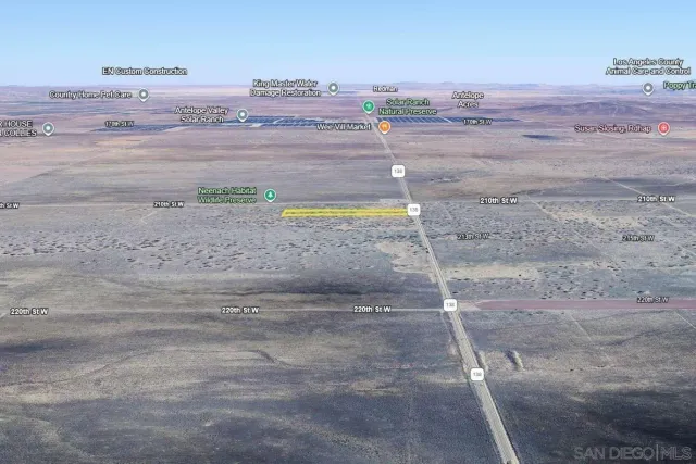 a view of a dry yard with wooden fence