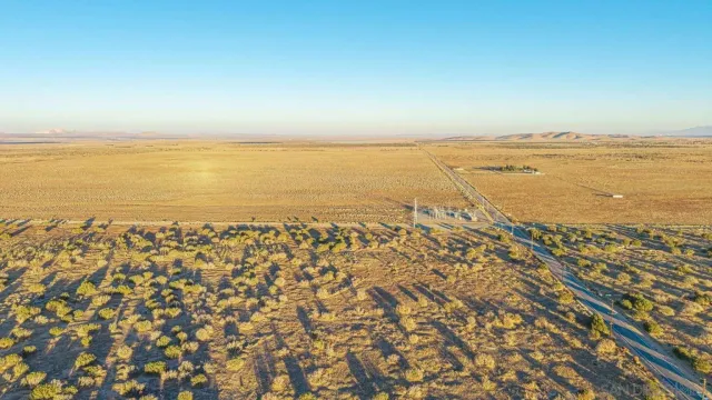 an aerial view of ocean and residential houses with outdoor space