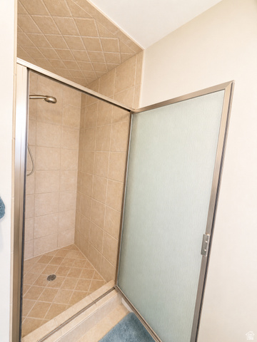 1020 Wilmar Place Centerville, UT 84014 - Photo 9 of 22 Tiled shower enclosure featuring a bronze-finish shower head and a textured glass door with brushed metal framing