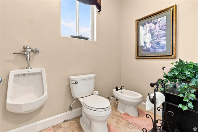 11290 South Southfield Road Mayfield, UT 84643 - Photo 67 of 103 Beige-painted walls featuring a window with a valance, a white wall-mounted urinal, and a white toilet