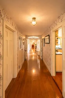a view of a hallway view with wooden floor and living room