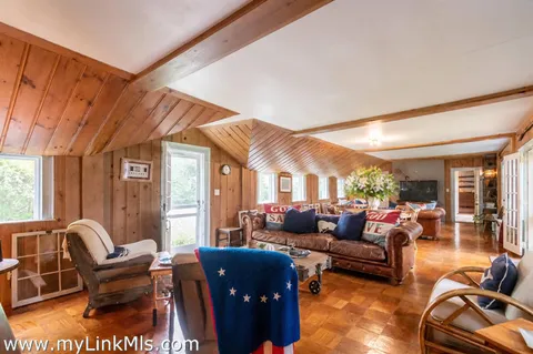a living room with furniture a fireplace and large windows