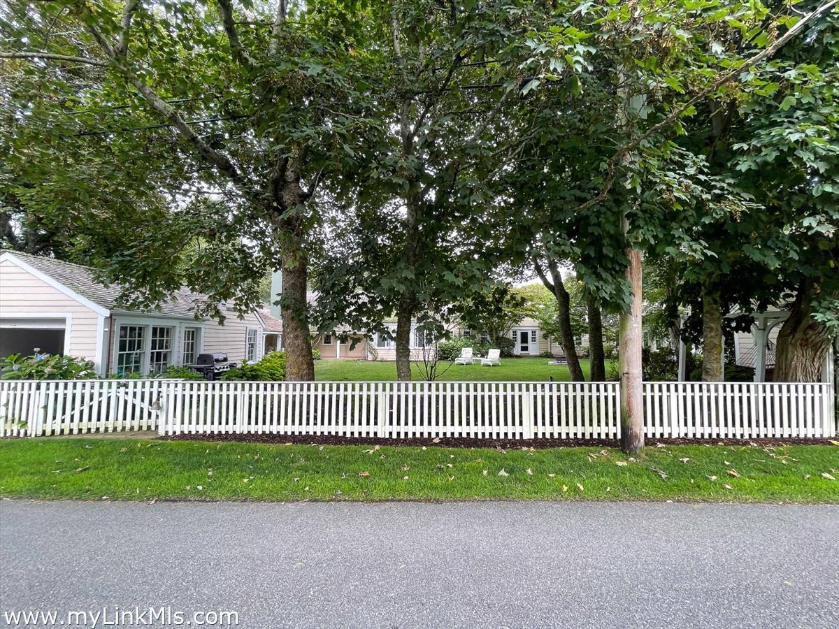 20 Main Street Nantucket, MA 02554 - Photo 29 of 33 a view of a bench in front of a yard with wooden fence