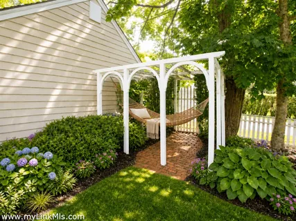 a view of a house with a small yard and wooden fence