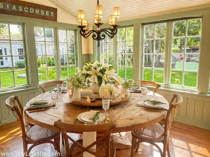 a dining room with furniture a chandelier and wooden floor