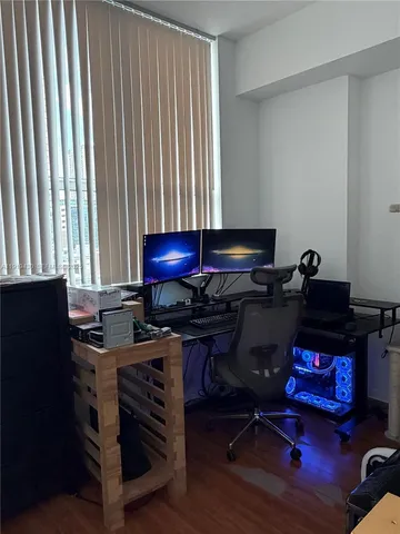 a view of a workspace with furniture and a window