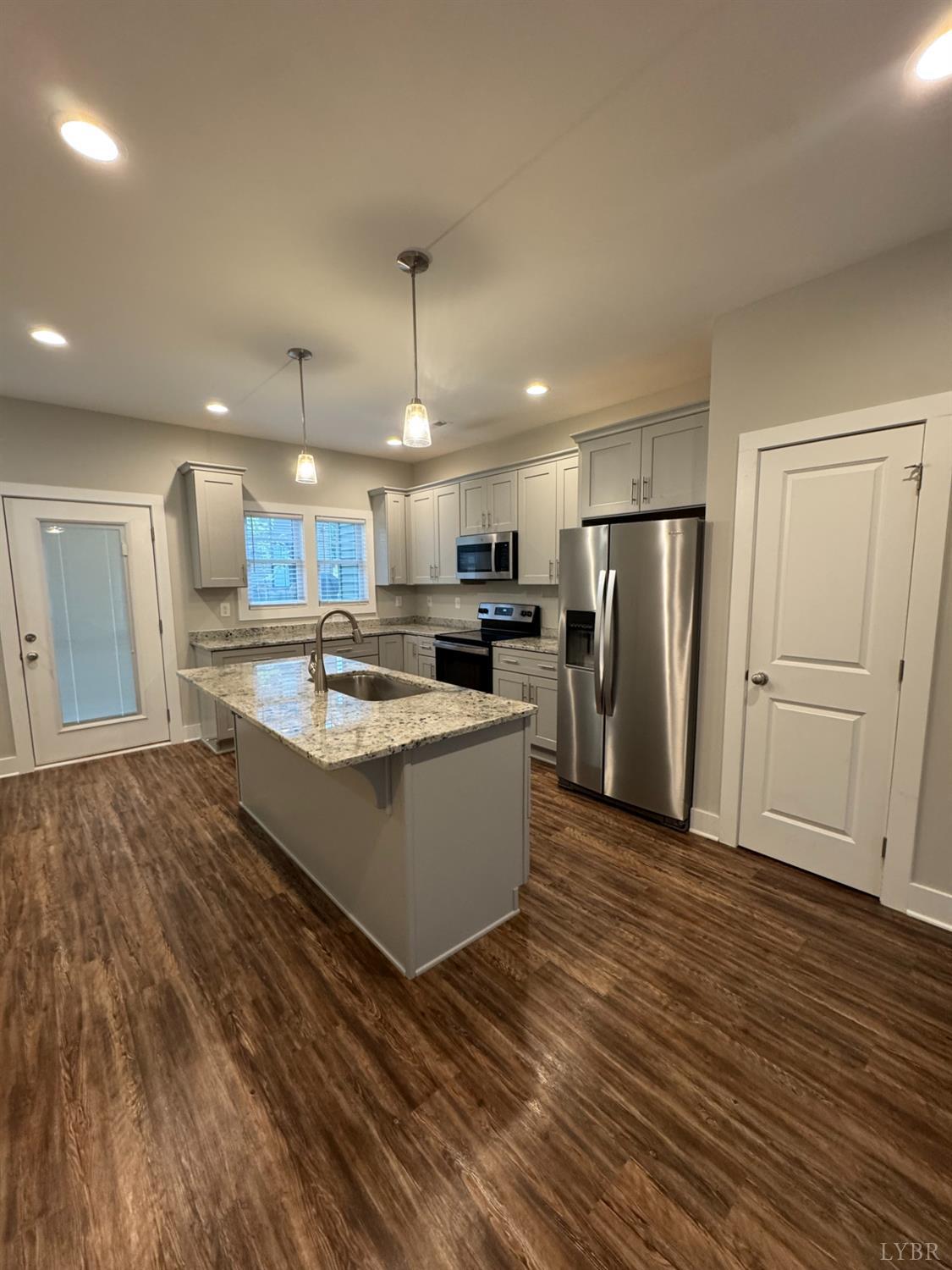 76 High Street Lynchburg, VA 24501 - Photo 6 of 22 a large kitchen with stainless steel appliances a large counter top and wooden floors