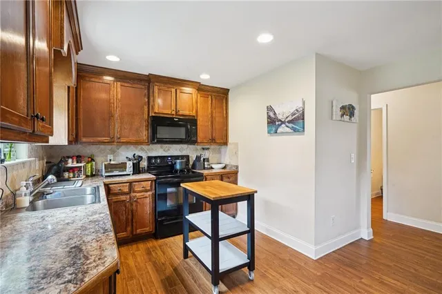 a kitchen with stainless steel appliances granite countertop a refrigerator stove top oven and sink