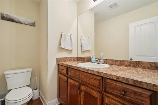 a bathroom with a granite countertop toilet sink and mirror