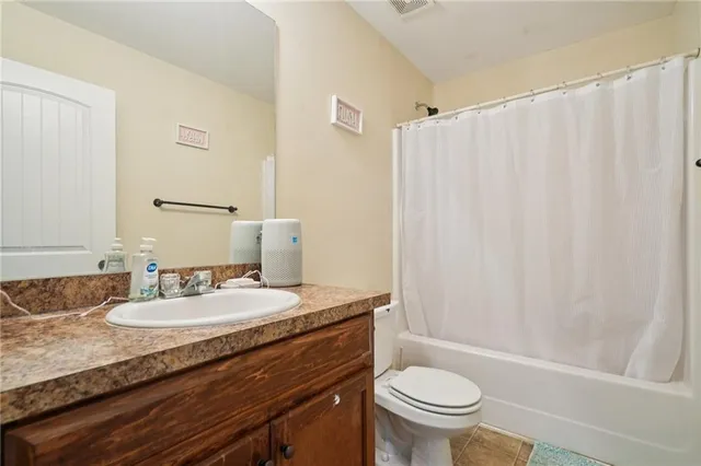 a bathroom with a granite countertop sink a toilet and a mirror