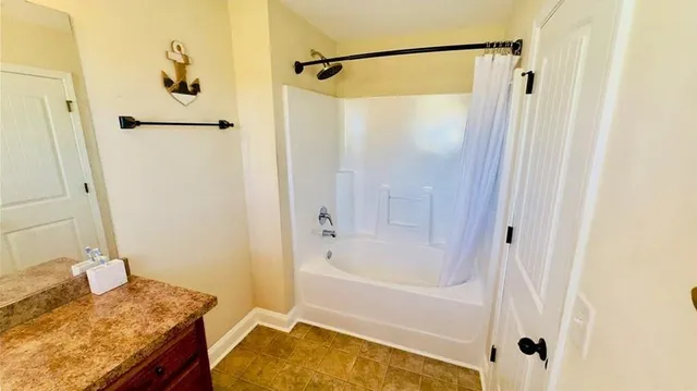 a bathroom with a granite countertop shower sink and vanity