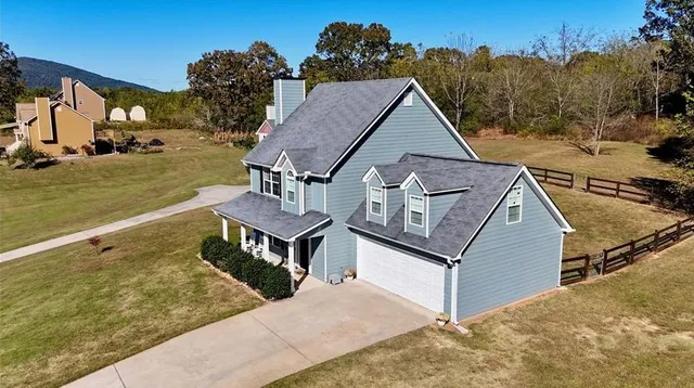 an aerial view of a house with a garden and mountain view