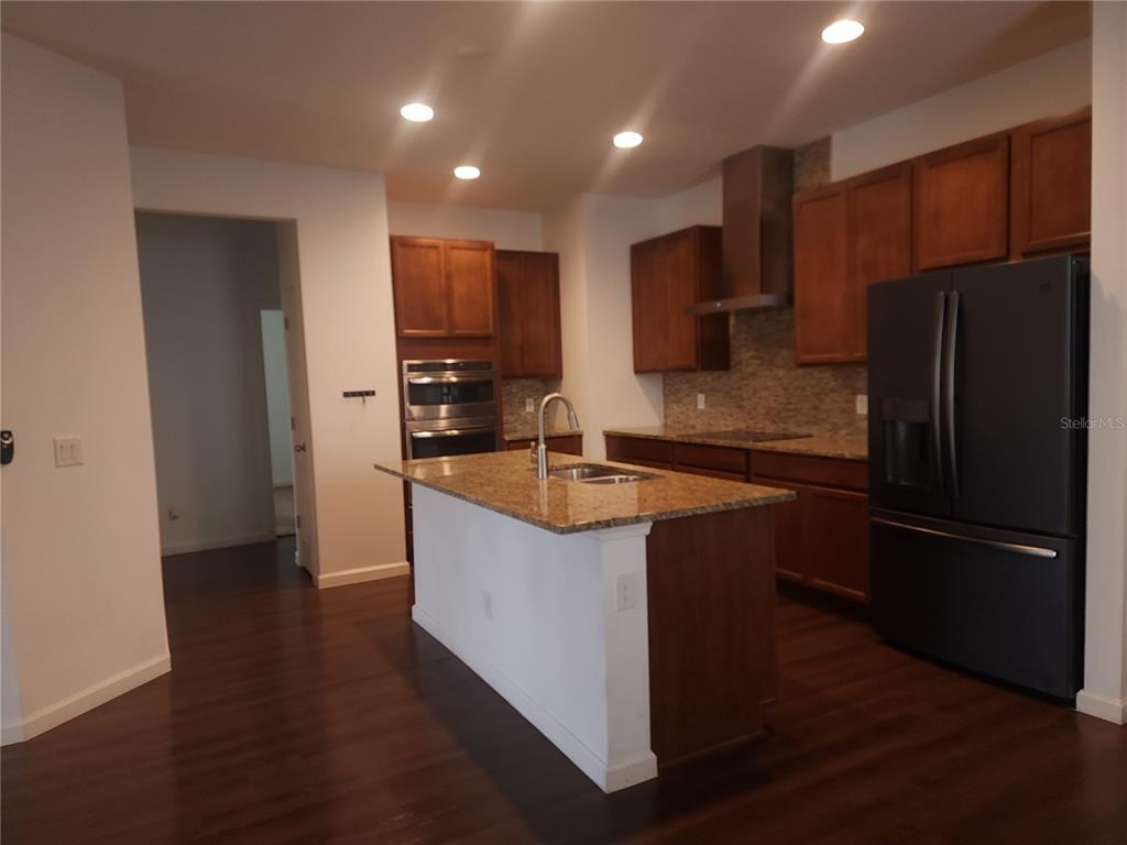 3230 Stratton Circle Kissimmee, FL 34744 - Photo 12 of 28 a kitchen with stainless steel appliances granite countertop a refrigerator a sink and a stove