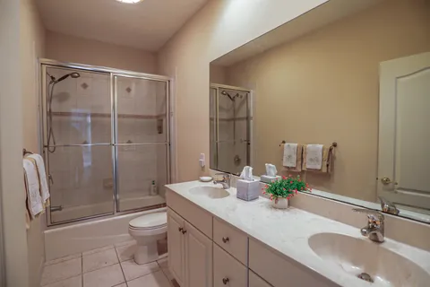 a bathroom with a shower sink vanity mirror and toilet