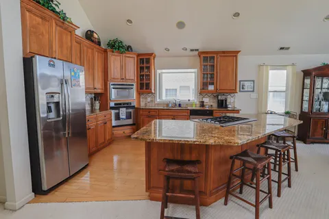 a kitchen with stainless steel appliances granite countertop a stove refrigerator and a refrigerator