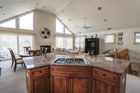 a kitchen with granite countertop a stove and white cabinets