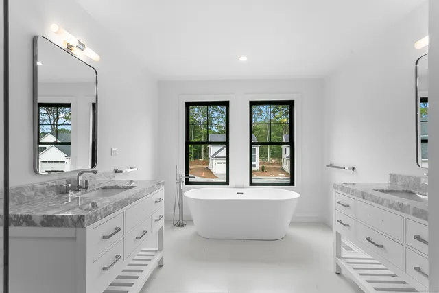 a bathroom with a granite countertop sink mirror and window