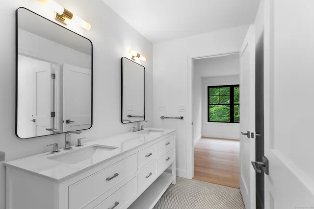 a bathroom with a double vanity sink mirror and bathtub