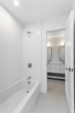 a bathroom with a tub a sink and a mirror