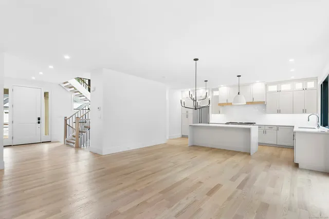 a large kitchen with a lot of counter space and wooden floor