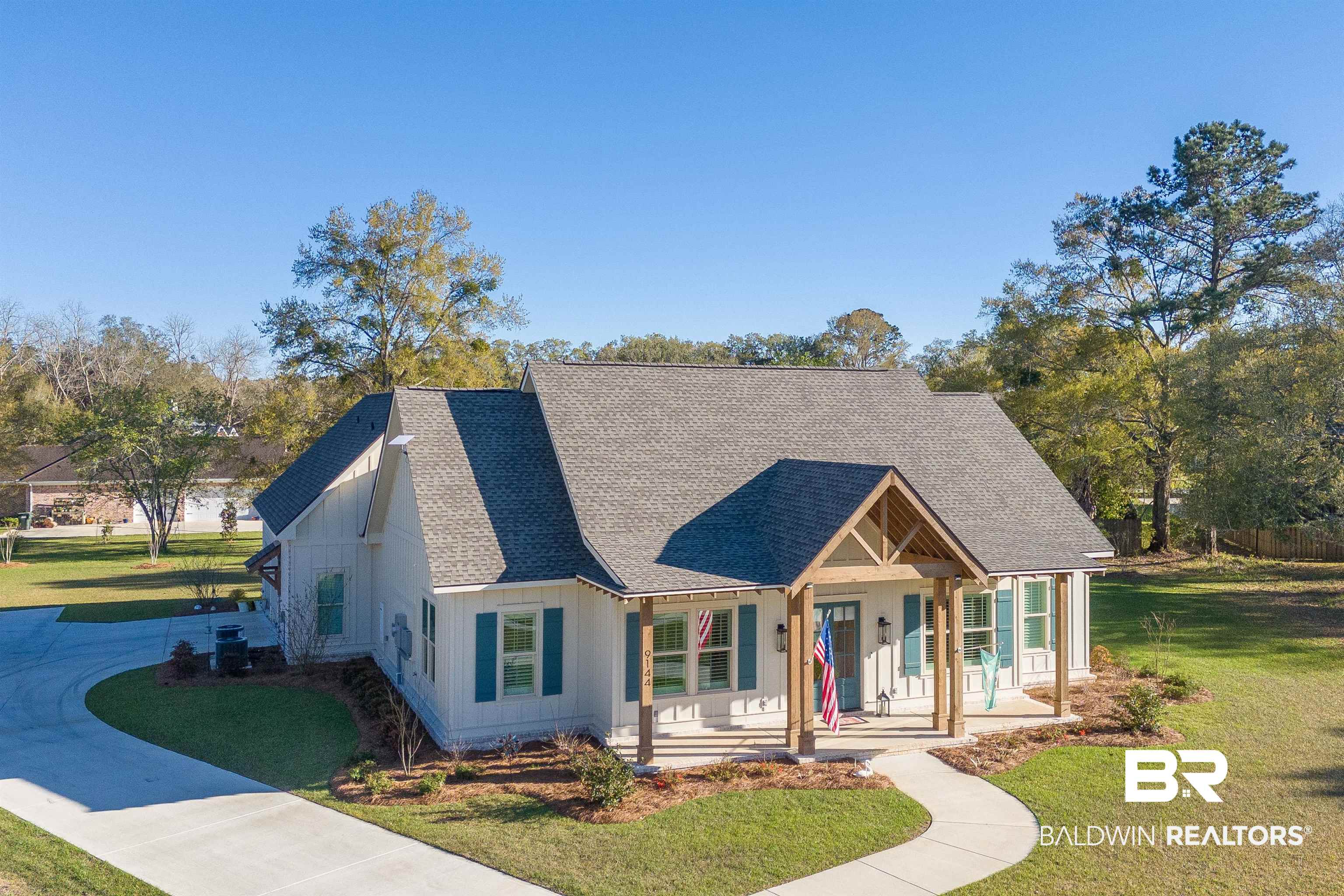 9144 Harvest Ridge Fairhope, AL 36532 - Photo 7 of 58 View of front facade featuring driveway, a front yard, covered porch, board and batten siding, and a shingled roof