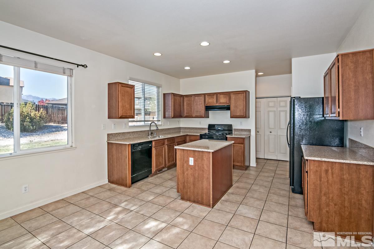 2324 Clementine Lane Reno, NV 89521 - Photo 6 of 23 a large kitchen with stainless steel appliances granite countertop a stove a sink dishwasher a refrigerator and a oven with wooden cabinets
