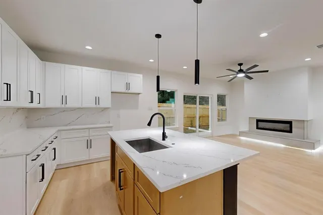 a large white kitchen with wooden floors and stainless steel appliances